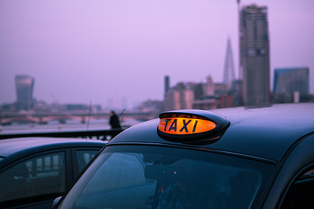 Close-up shot of a classic black London taxi with the light on at sunset on the River Thames near Westminster in London, England. This image was captured with a Canon 5D DSLR thumbnail