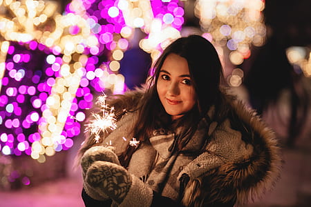 smiling woman holding sparkler thumbnail
