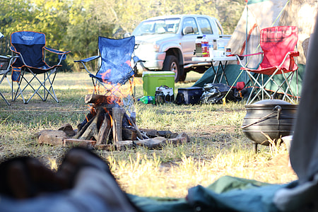 bonfire on camping site near pickup truck thumbnail