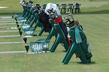 golf club in bags beside baskets on field thumbnail