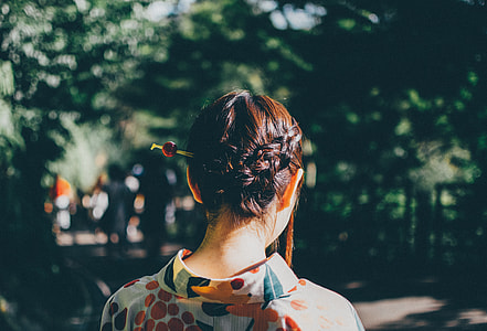 back of woman with stick on braided hair thumbnail