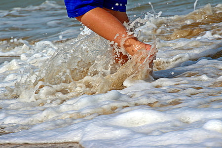 person in blue bottoms walking on beach thumbnail