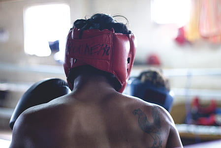 person wearing red boxing headgear and black glove thumbnail