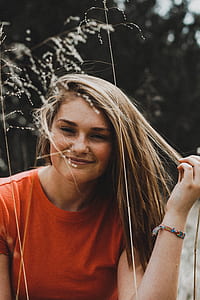 woman holding her hair near Indian goose grass during daytime thumbnail