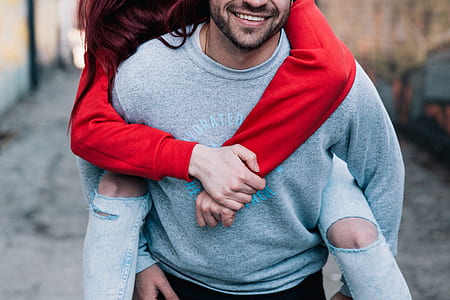 man wearing grey sweater with woman wearing red sweater thumbnail