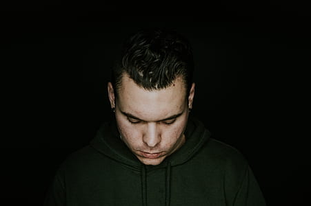 portrait photography of man against black background thumbnail