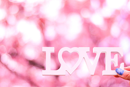 boke light photography of person holding Love free standing letters thumbnail