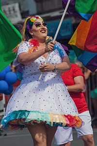 Woman in Multicolored Polka-dot Dress Holding Flag thumbnail