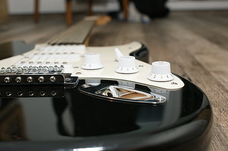 black and white electric guitar on floor thumbnail