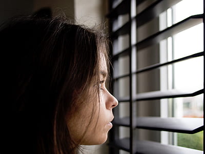 black-haired woman looking at the window during daytime thumbnail