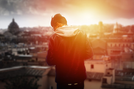 selective focus of man standing front of houses and building during golden hour thumbnail