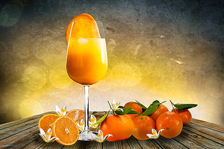 wine glass with orange juice on brown wooden table thumbnail
