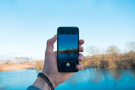 person holding black smartphone with turned-on screen capturing the view thumbnail
