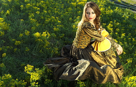 woman sitting on yellow flower field taken under white clouds during daytime thumbnail