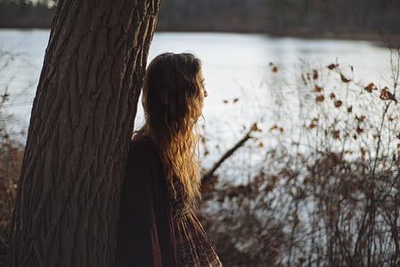 woman standing beside tree thumbnail