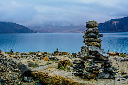balance stone near body of water thumbnail