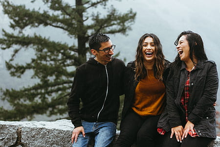 three person sitting on rock laughing thumbnail