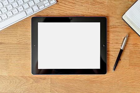 black iPad on top of brown wooden surface thumbnail