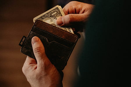 person holding wallet with 1 U.S. dollar banknote thumbnail