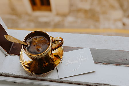 Drink coffee in a golden cup at the window thumbnail
