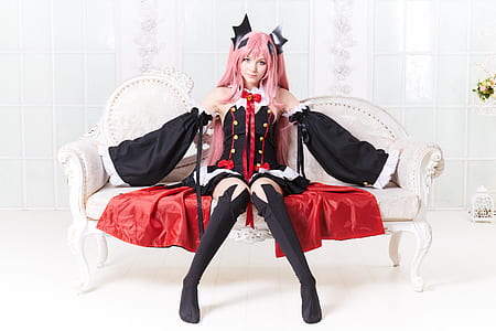 female cosplayer wearing black and red mini dress sitting on sofa thumbnail