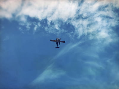 low-angle photo of plane flying under blue sky thumbnail