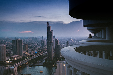 man standing on terrace above buildings thumbnail