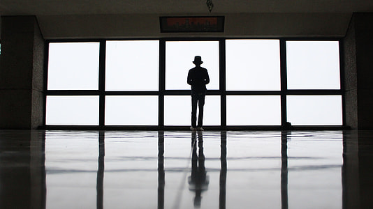 person standing behind glass mirror thumbnail