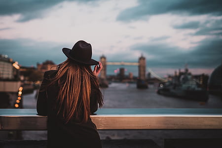 woman wearing black hat looking on Tower Bridge thumbnail