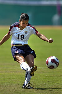 focus photo of woman kicking soccer ball on green grass field thumbnail