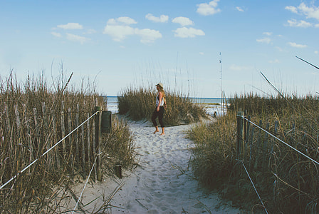 woman on grey sand towards sea thumbnail
