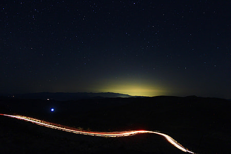 timelapse photo of road under white stars at nightime thumbnail