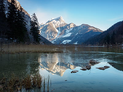 body of water in the middle of mountains during daytime thumbnail