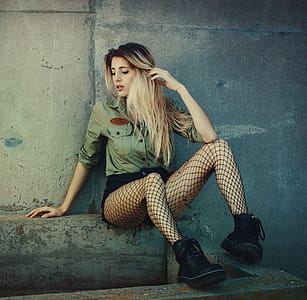 Woman Sitting on Concrete Seat While Wearing Green Button-up Long-sleeved Shirt and Mesh Stockings thumbnail