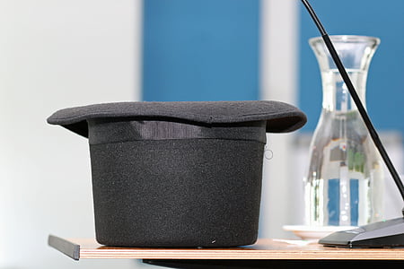 black top hat beside glass vase thumbnail
