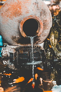 water pouring through brown clay pot thumbnail