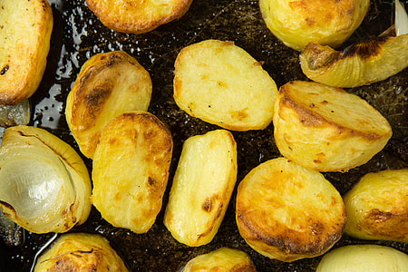 Roast potatoes and onions in baking tray thumbnail