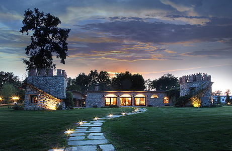 white concrete buildings surrounded with green grass field and trees during golden hour thumbnail