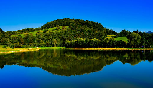 panoramic photography of hill with body of water thumbnail