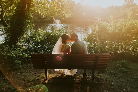 man and woman kissing while sitting on the bench thumbnail