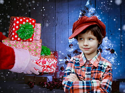 Photo illustration of young boy looking at stack of Christmas presents handed to him by Santa Clause thumbnail