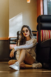 woman sitting near black leather sofa thumbnail