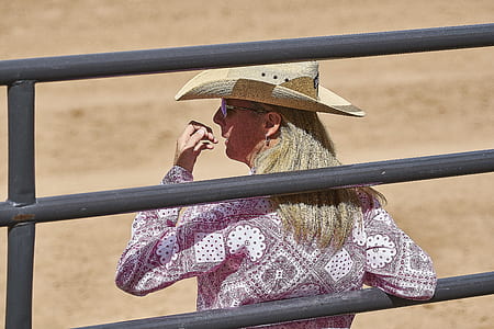 woman standing behind gray steel fence thumbnail