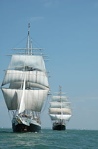 white and black ships under blue sky photography thumbnail
