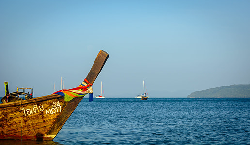 brown boat on sea under blue sky thumbnail