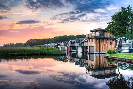 brown wooden house near body of water thumbnail