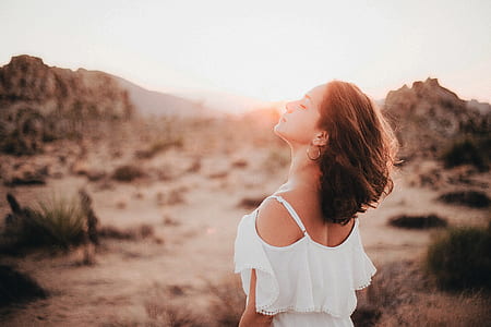 woman wearing white cold-shoulder shirt standing on desert during golden hour time thumbnail