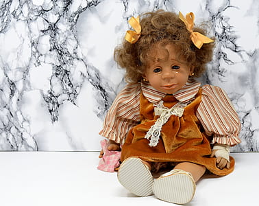 female doll leaning on white and black wall thumbnail