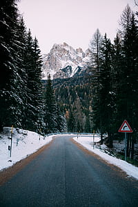 concrete road with snow-capped mountain at distance thumbnail