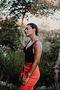 selective focus photography of woman wearing black spaghetti strap top and orange skirt thumbnail
